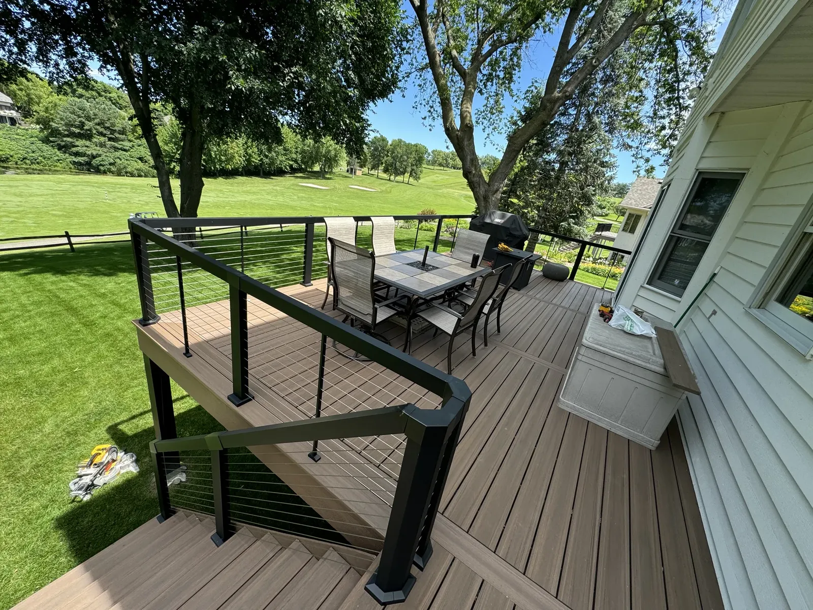 Composite deck with black railing overlooking a landscaped yard