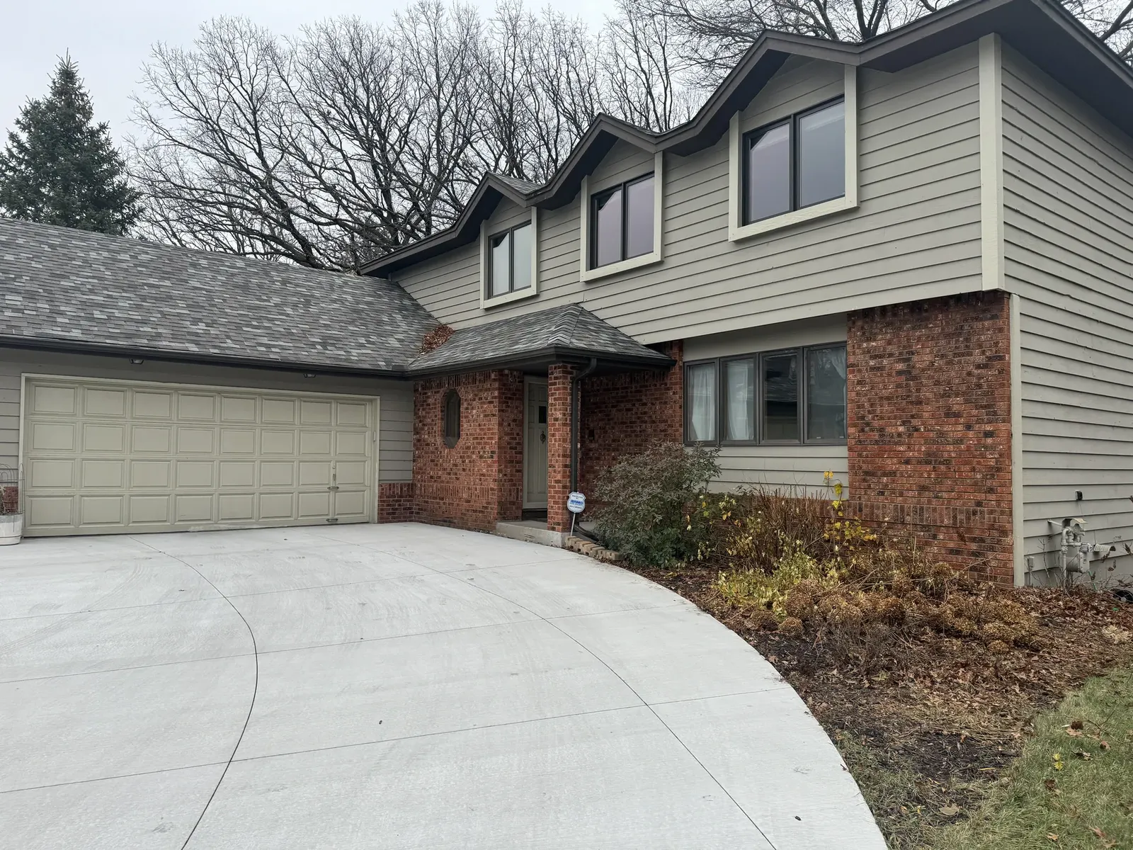 Brick-and-siding home exterior viewed from the driveway