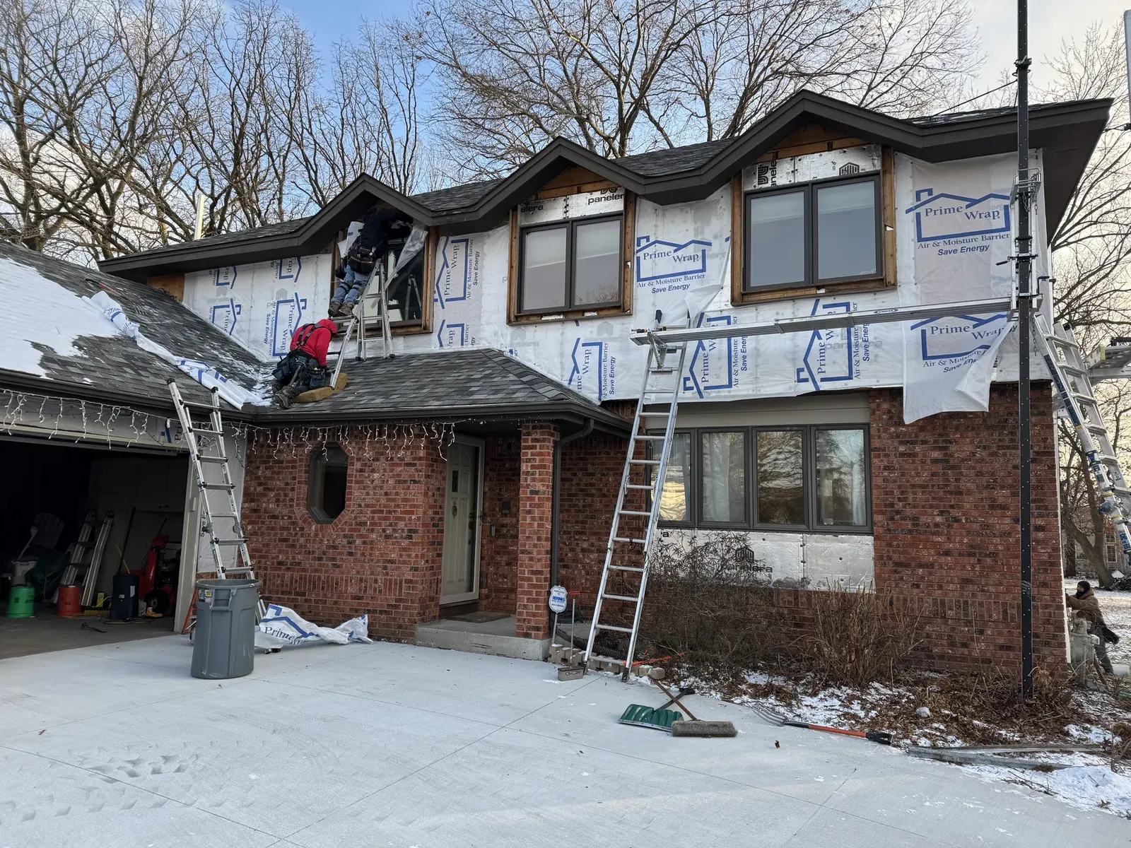 Exterior-envelope work in progress with housewrap and ladders