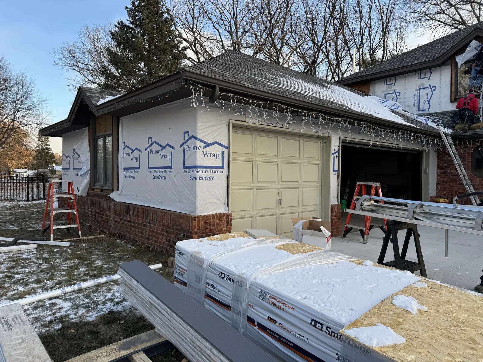 Exterior-envelope work in progress around a garage and upper siding