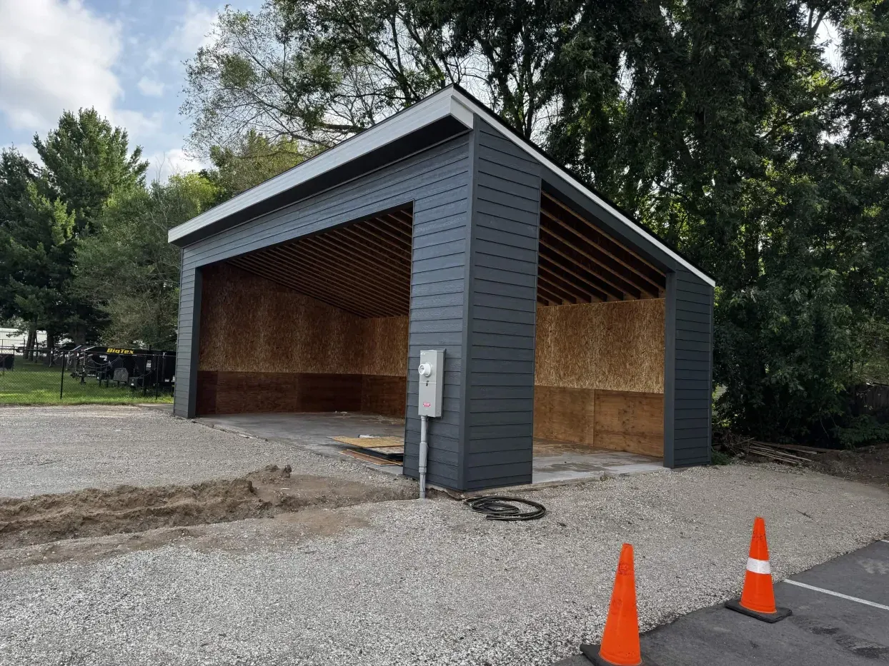 Opposite-angle view of siding and roofline progress at The Hideout