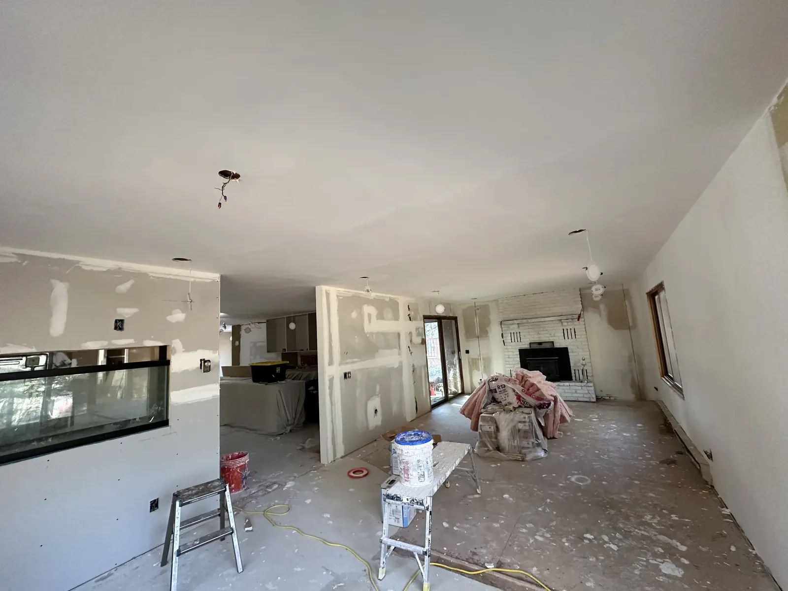 Interior remodel progress with drywall, tools, and work materials