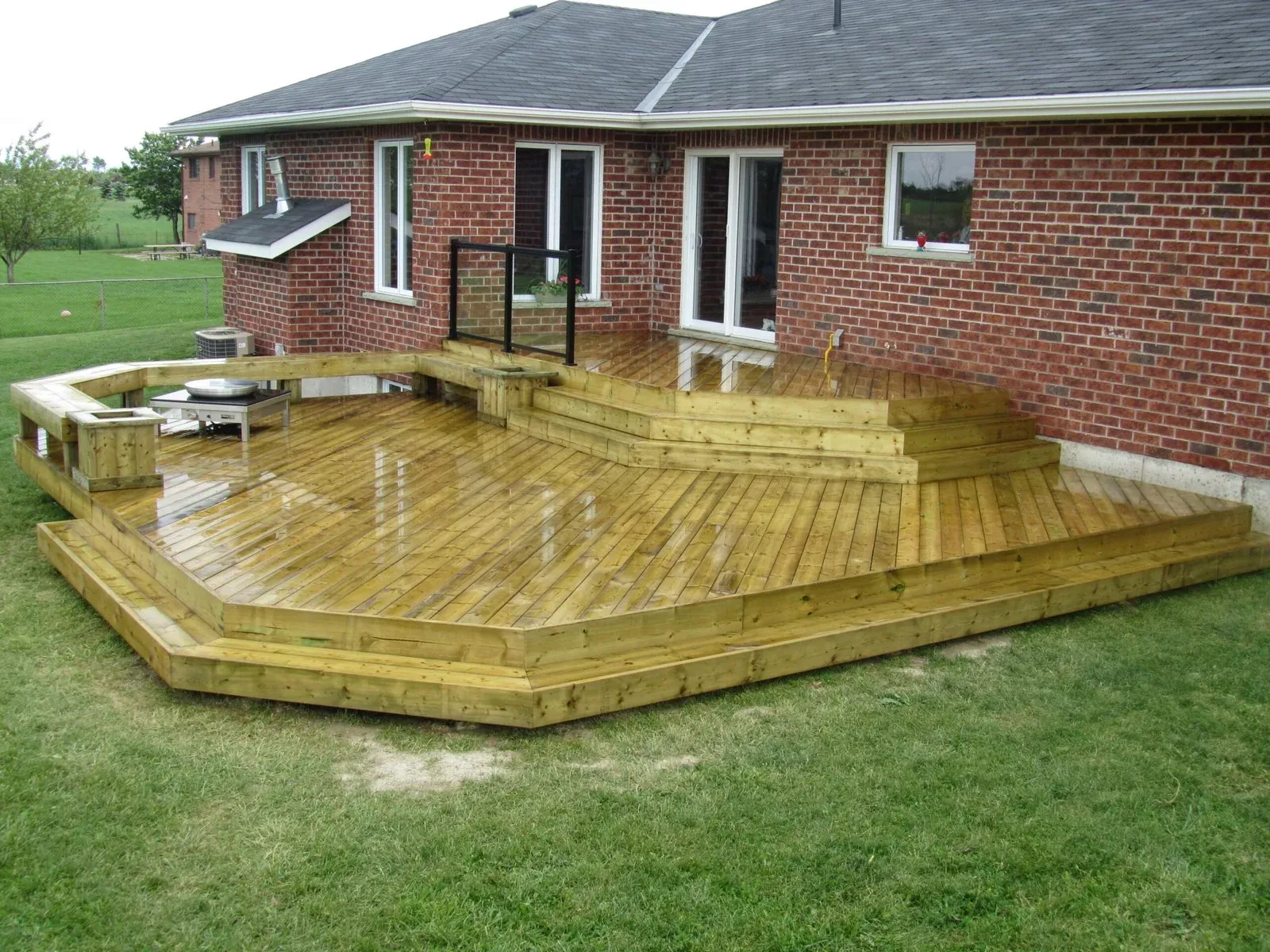 Low-profile wood deck outside a brick home