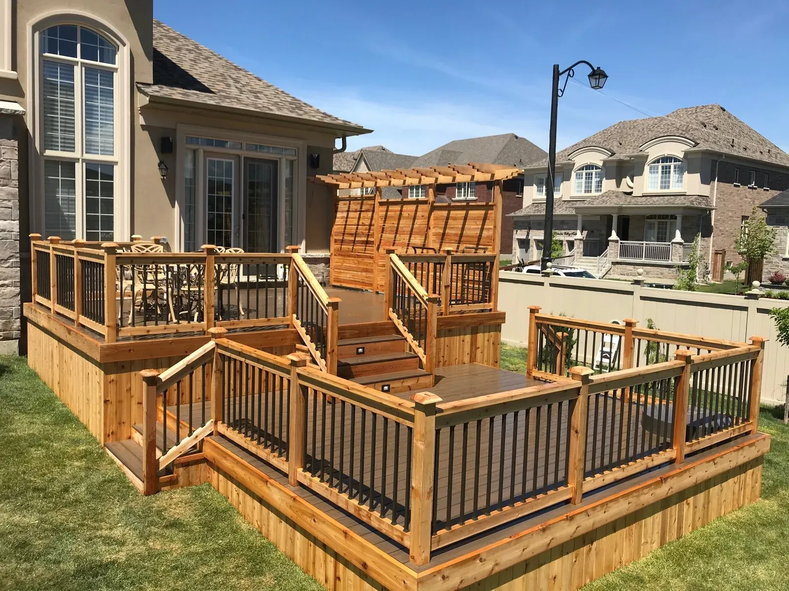 Multilevel wood deck with black railing and stairs
