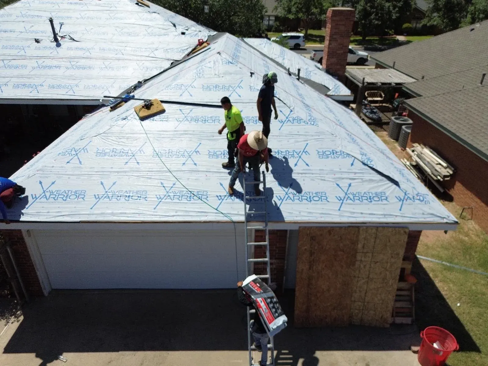 Roof crew working over underlayment during replacement