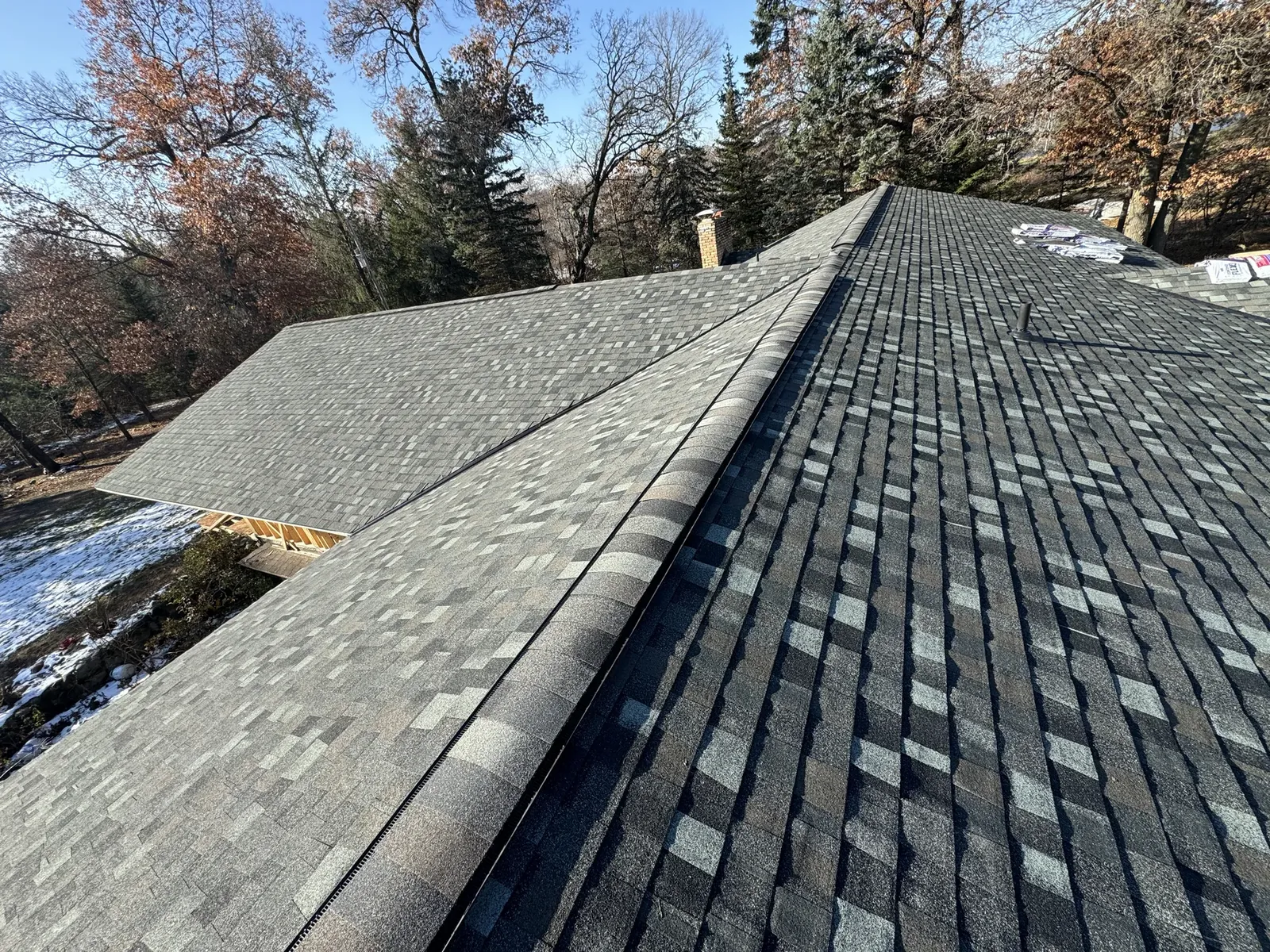 Close view across an asphalt-shingle roof and ridge lines
