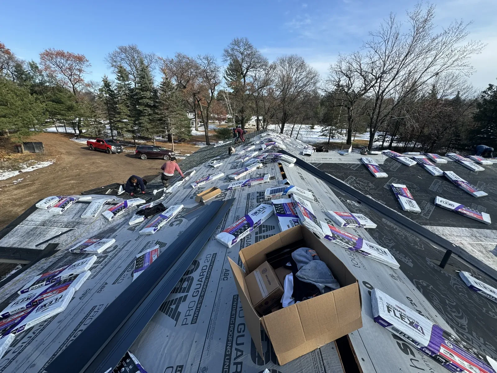 Roof replacement in progress with shingle bundles staged across the roof